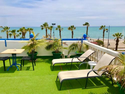 a beach area with chairs, tables and umbrellas at Guadalupe Cozy Inns in Torremolinos