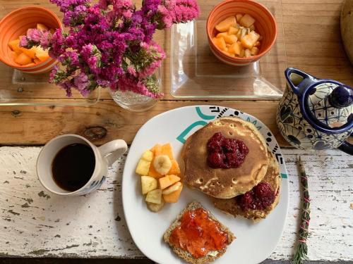 a plate of food with a sandwich and a cup of coffee at Hostal La Isla in San Cristóbal de Las Casas