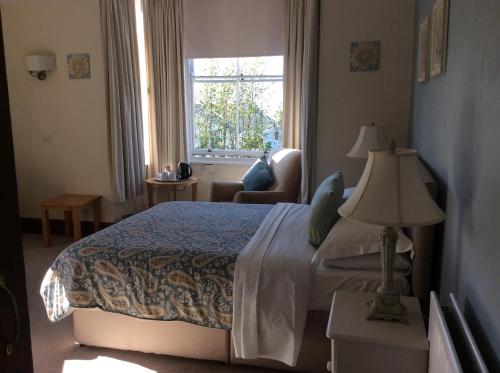 a hotel room with a bed and a window at Bron Aber in Criccieth