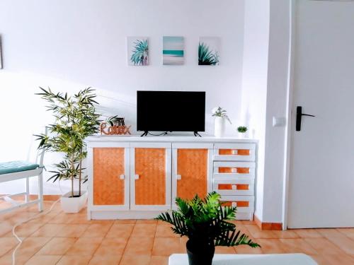 a living room with a tv on a cabinet at Lovely apartment 500 m walk to the beach in Portimão