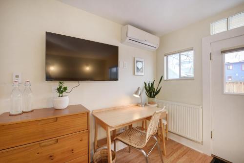 a dining room with a table and a tv on the wall at Boulder Guest House in Boulder