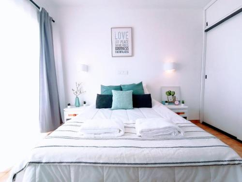 a bedroom with a large white bed with towels on it at Lovely apartment 500 m walk to the beach in Portimão
