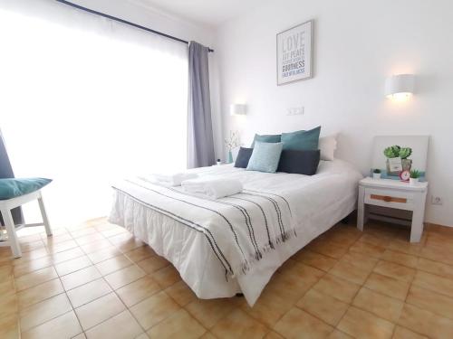 a white bed in a room with a large window at Lovely apartment 500 m walk to the beach in Portimão