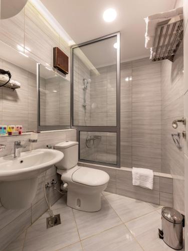 a bathroom with a toilet and a sink and a shower at Royal Day Plaza Hotel in 6th Of October