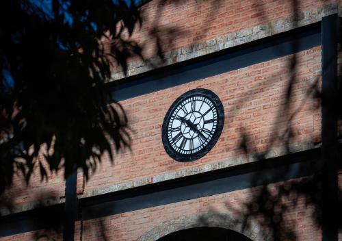 a clock on the side of a brick building at LA PIANTA - Uma experiência na Villa de Monte Verde in Monte Verde