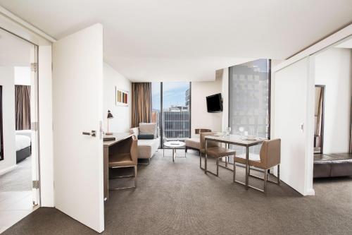 ein Wohnzimmer mit Tisch und ein Esszimmer in der Unterkunft Mantra Collins Hotel in Hobart