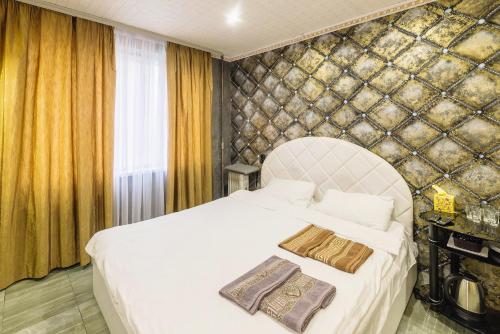 ein Schlafzimmer mit einem großen weißen Bett mit zwei Kissen in der Unterkunft Смарт Апартаменты джакузи in Dnipro