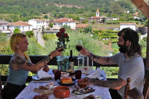 two people sitting at a table with glasses of wine at Quintinha D`Arga in Caminha