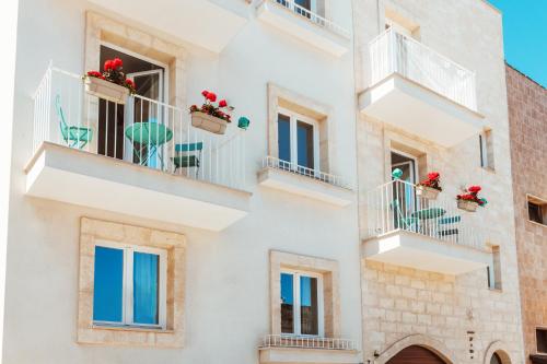 eine Fassade eines Gebäudes mit Balkonen und Blumen in der Unterkunft FeMa B&B-Housea Travel in Polignano a Mare