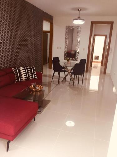 a living room with a red couch and a table at Verdana Rental Residencial Arlene II SFM in San Francisco de Macorís