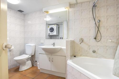 a bathroom with a sink and a toilet and a shower at A Taste of the Tropics in Cairns