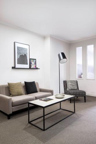 a living room with a couch and a coffee table at Mantra on Little Bourke Melbourne in Melbourne