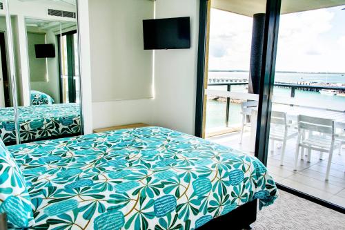 1 dormitorio con cama y vistas al océano en Absolute Waterfront - Tropical Aurora Top Floor Over The Water, en Darwin