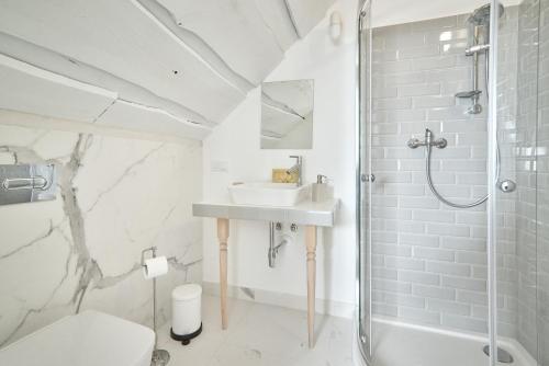 uma casa de banho branca com um lavatório e um chuveiro em Dom Pujszany em #N/A