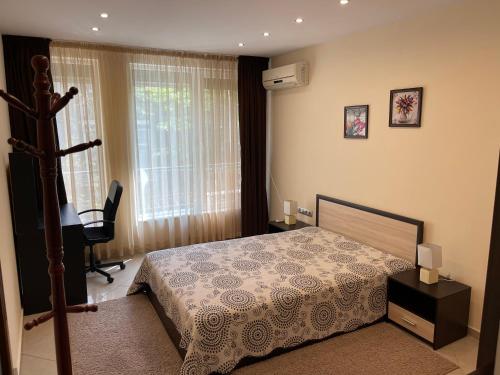 een slaapkamer met een bed, een bureau en een raam bij Top Central/Location 2 Bdr , 2 Bathroom Apartment in Varna