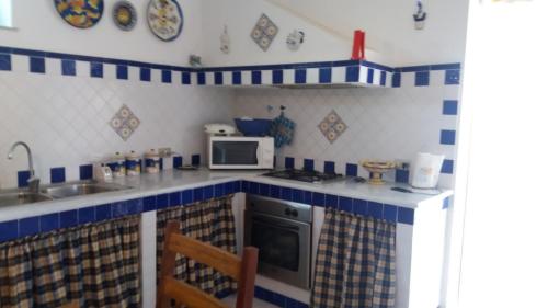 a kitchen with blue and white tiles on the counters at Gorgo House in Lascari