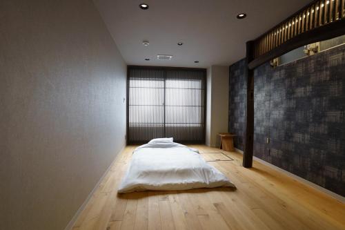 a bedroom with a bed on a wooden floor at Hotel San Hiroshima in Hiroshima