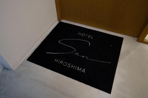 a black mat with the name of a hotel on the floor at Hotel San Hiroshima in Hiroshima