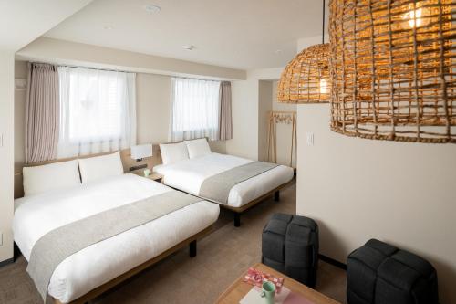 a hotel room with two beds and a chandelier at BON Kyoto Kiyomizu in Kyoto