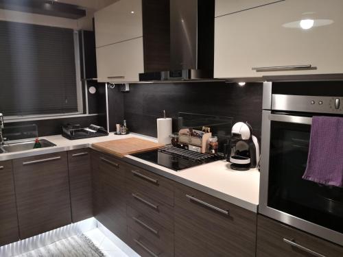 a kitchen with brown cabinets and a stove top oven at Luxury Home in Spáta