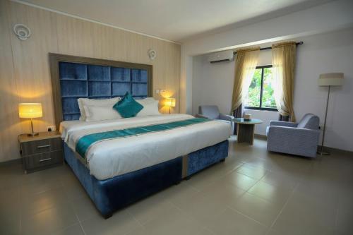 a hotel room with a large bed and a chair at Riviera Suites in Lagos