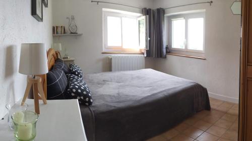 a bedroom with a bed and a table with a lamp at GITE LA ROCHE in Le Boulvé