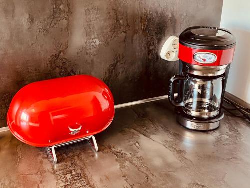 a red chair sitting on a counter next to a coffee maker at COAST HOUSE River Docks in Bremerhaven