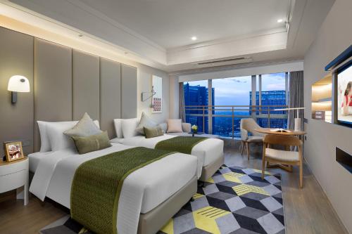 two beds in a hotel room with a view at Citadines Keqiao Shaoxing in Shaoxing