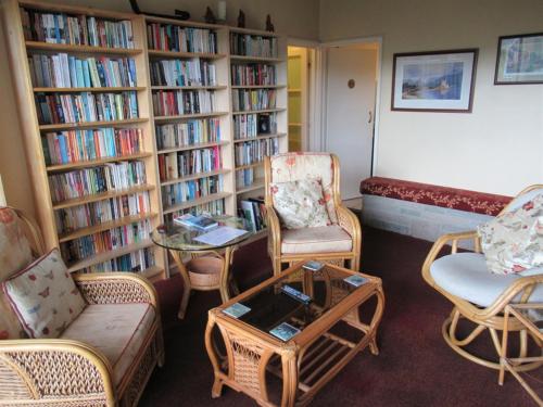 a living room with book shelves filled with books at Avoncourt Lodge in Ilfracombe