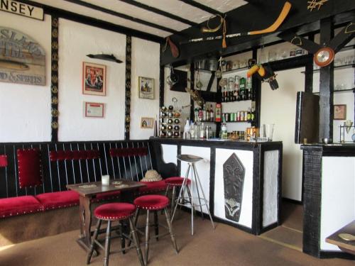 un bar en un restaurante con taburetes rojos en Avoncourt Lodge en Ilfracombe