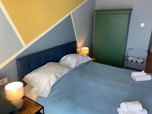 a bedroom with a blue bed and a green cabinet at Hotel Elu Iris in Split