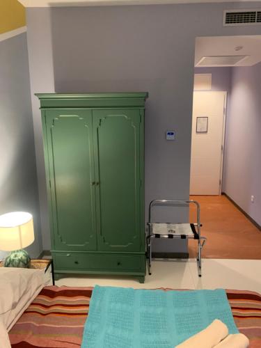 a green cabinet in a room with a bed at Hotel Elu Iris in Split