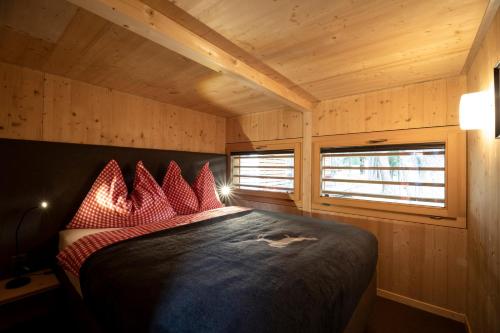 ein Schlafzimmer mit einem Bett in einer Holzhütte in der Unterkunft Camping Gravatscha in Samedan