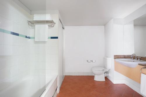 a bathroom with a toilet and a sink at Mantra on The Esplanade in Darwin