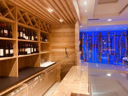 a tasting room with a tub and a wine cellar at Alpholiday Dolomiti Wellness & Family Hotel in Dimaro