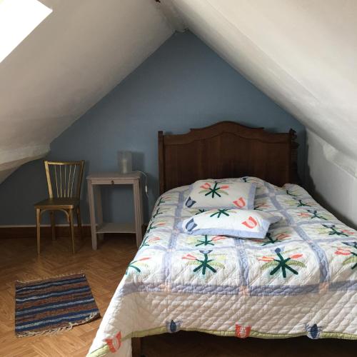 a bedroom with a bed and a chair in a attic at LA MAISON de GUSTAVE 20MN BEAUVAL in Vicq-sur-Nahon
