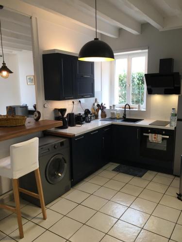a kitchen with a sink and a washing machine at LA MAISON de GUSTAVE 20MN BEAUVAL in Vicq-sur-Nahon
