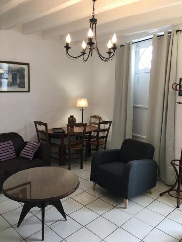 a living room with a couch and a table at LA MAISON de GUSTAVE 20MN BEAUVAL in Vicq-sur-Nahon