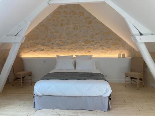 a bedroom with a large bed in an attic at Les Hauts de Grillemont in Cinq-Mars-la-Pile
