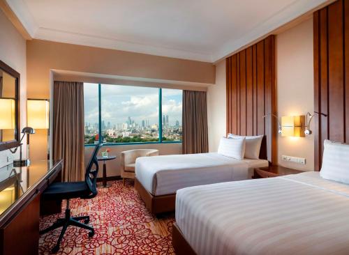 سرير أو أسرّة في غرفة في Hotel Ciputra Jakarta managed by Swiss-Belhotel International
