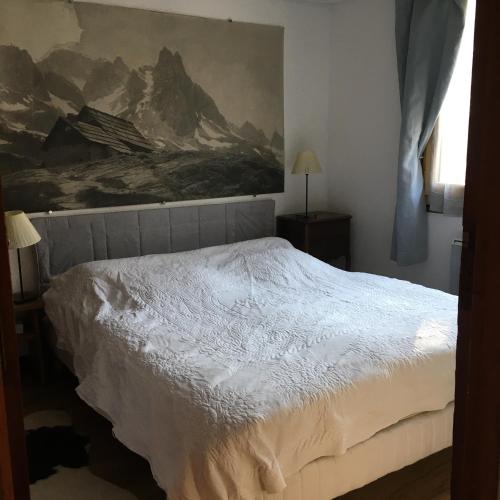 a bedroom with a bed with a painting on the wall at Chalet Nicouski in La Salle Les Alpes