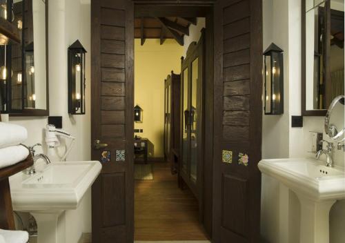 a bathroom with two sinks and two mirrors at The Tamara Kodai in Kodaikānāl