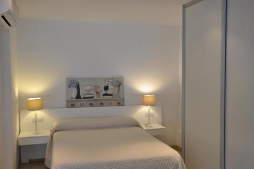 バレンシアにあるValencia City Center New Apartmentsのベッドルーム(ベッド2台、ランプ2つ付)