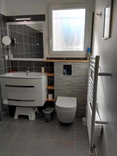 a bathroom with a toilet and a sink and a window at La Cigale - Pte des Gorges - Piscine privée chauffée in Vallon-Pont-dʼArc