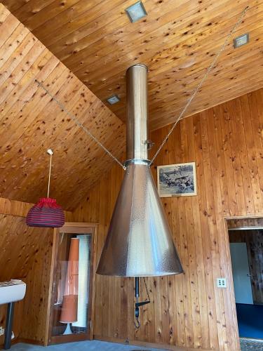 a large metal object hanging from a wooden ceiling at 花緑里-Hanamidori-そしの山荘 岐阜下呂金山郡上貸切ロッジ高原リゾート in Gujo