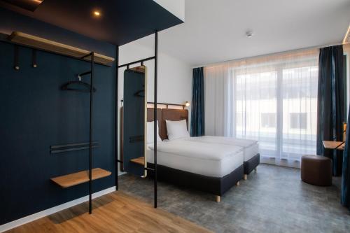 1 dormitorio con cama y ventana grande en H2 Hotel Budapest, en Budapest