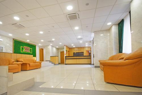 a lobby with two orange chairs and a kitchen at COMPLEX PANORAMIC in Slănic-Moldova