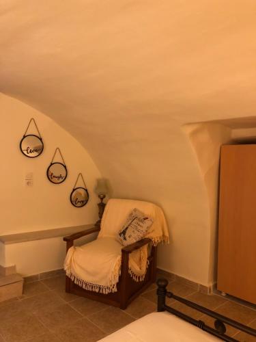 a small room with a chair and a tv at Kamares Cave House 3 in Gerolimenas