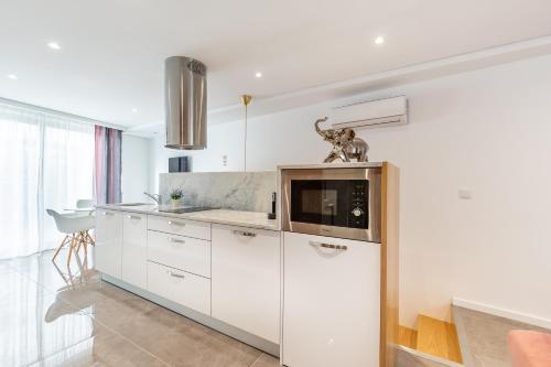 a kitchen with white cabinets and a microwave at Nell&And&Jess in Espinho