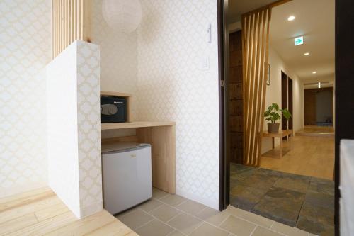 a hallway of a house with a tv and a room at Hotel San Hiroshima in Hiroshima
